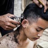 Laos - Taglio di capelli in strada nel paese di Muang Khua.
