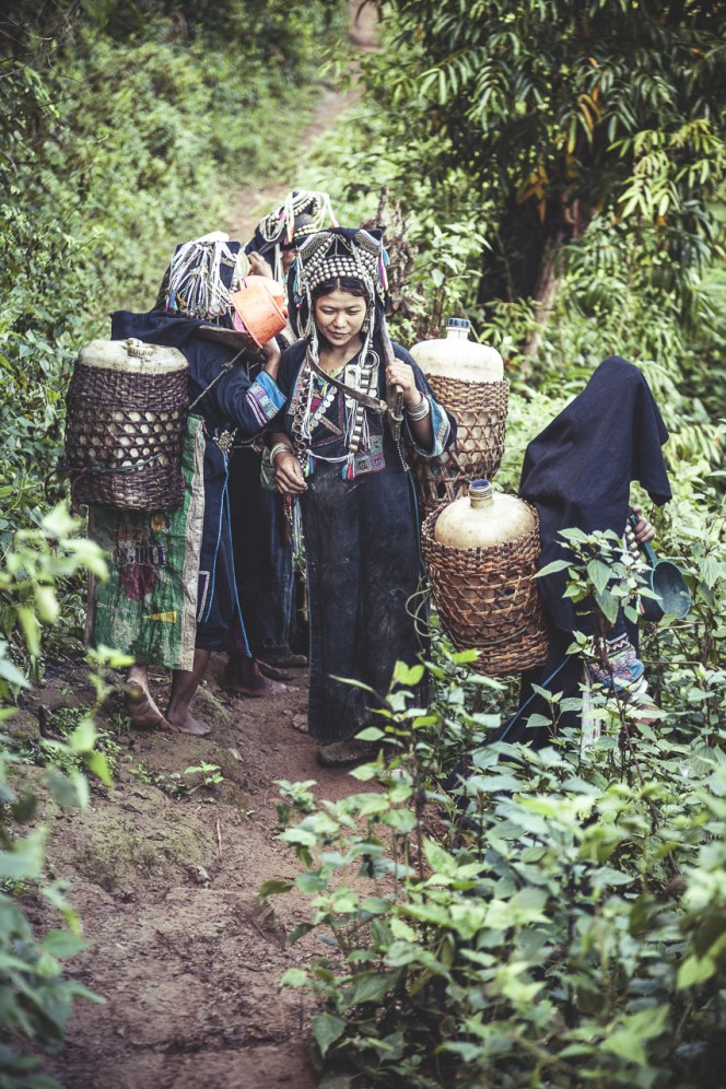 Laos - Donne della tribù degli Akha-Noukouy, nel loro compito quotidiano del procurarsi acqua dolce, per il fabbisogno della famiglia.